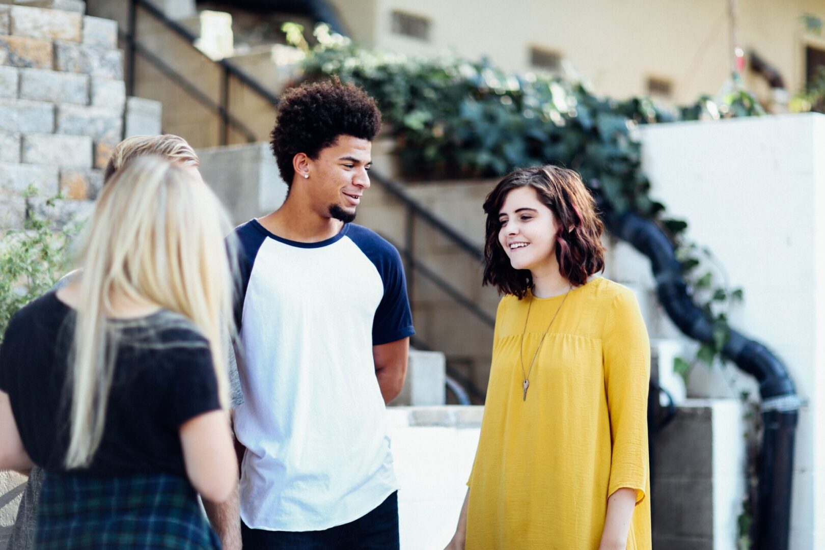 A group of people standing around talking to each other.