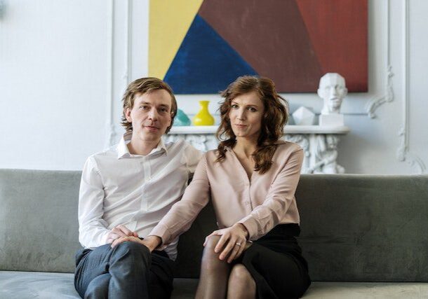 A man and woman sitting on top of a couch.